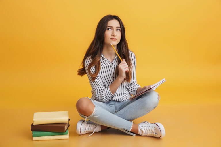 TOEFL x Cambridge: qual certificação escolher? | Retrato de uma jovem pensativa fazendo anotações | IP School